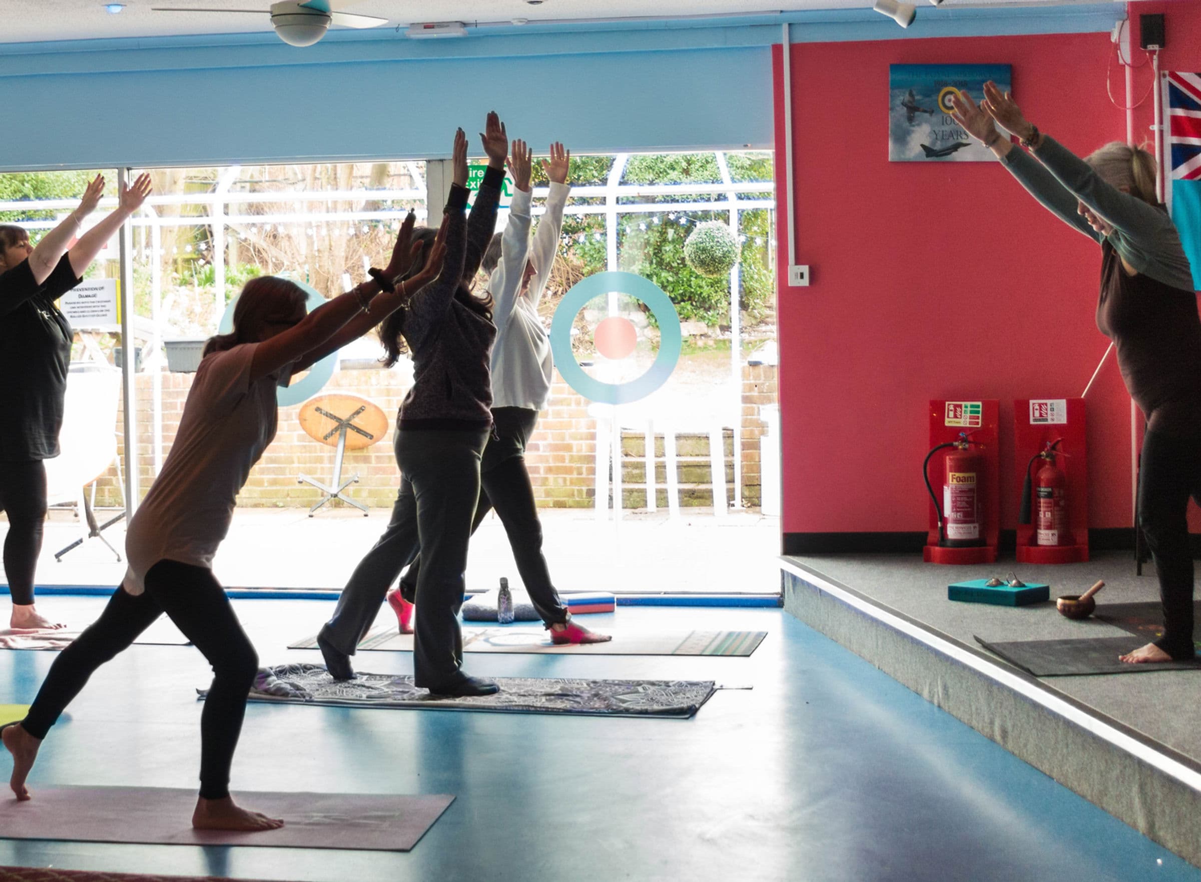 Standing yoga class in a bright modern room